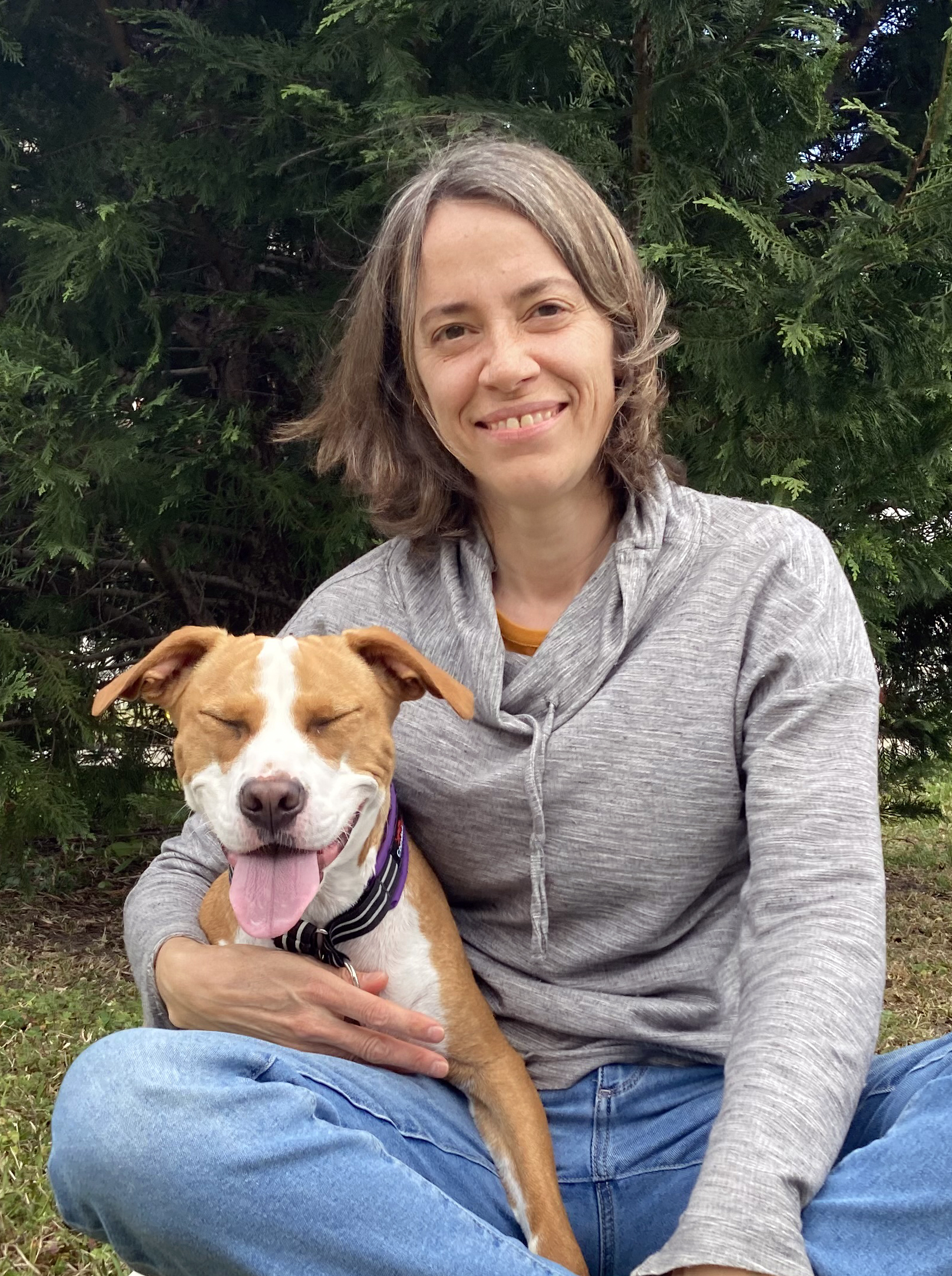 dog trainer Cheryl Shomo from Chesapeake hugging red and white Pitbull mix