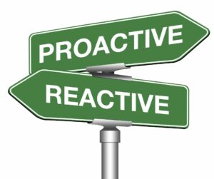 two signs reading Proactive and reactive pointing in opposite directions