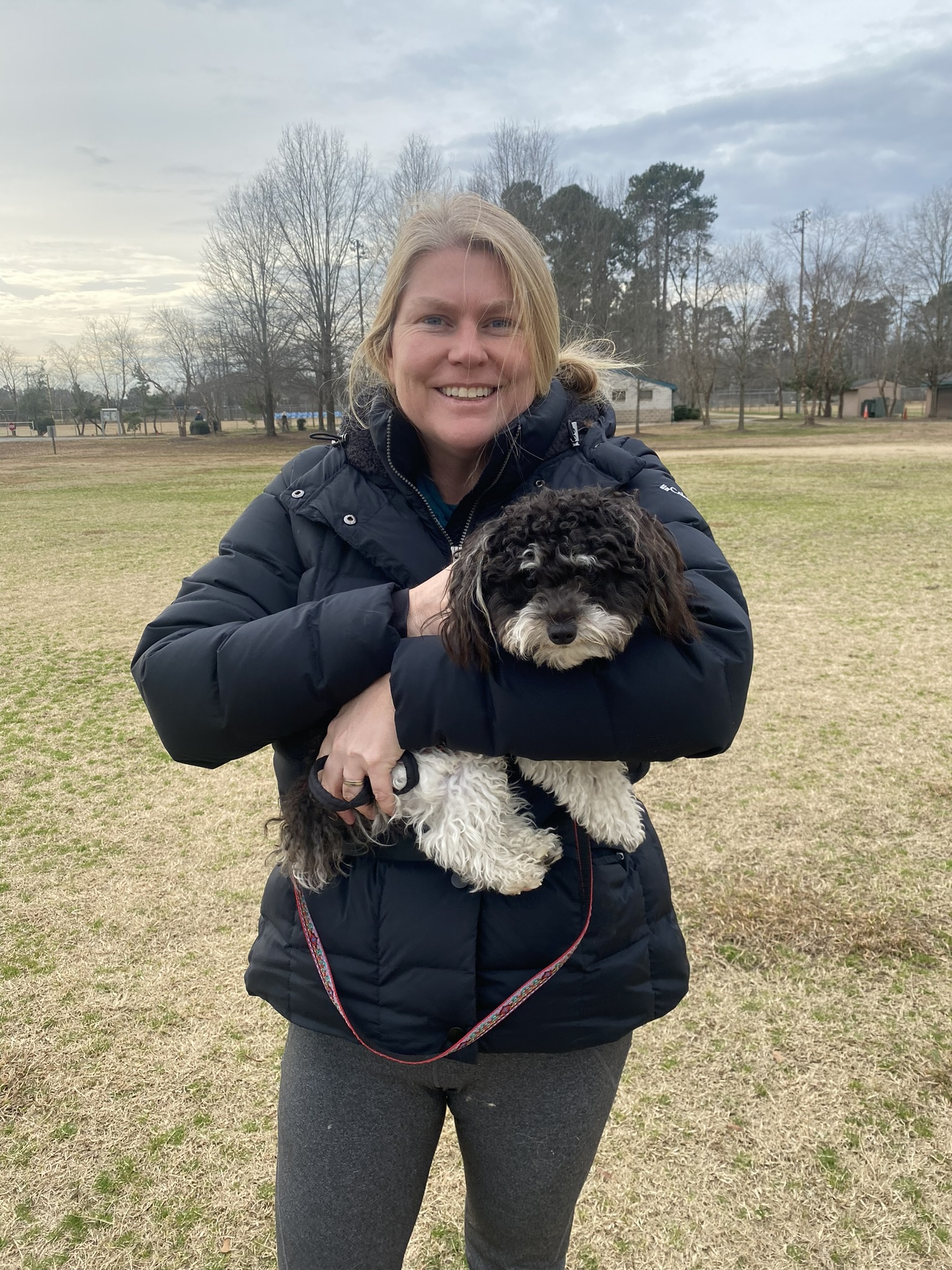 Trainer holding Mini Poodle at City View Park in Virginia Beach